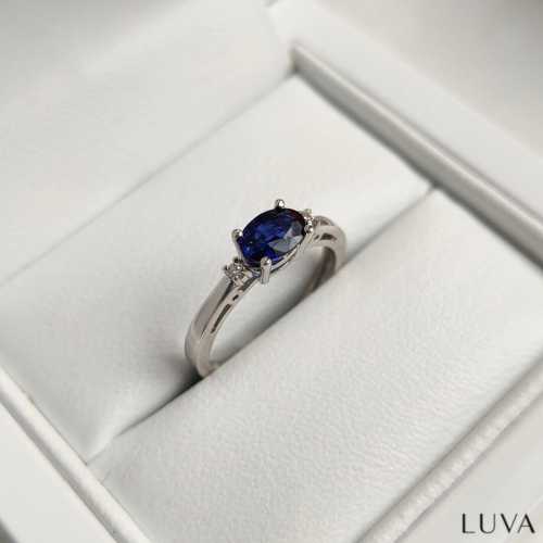 Romantyczny pierścionek zaręczynowy białe złoto z owalny, oprawionym podłużnie szafirem i brylancikami po bokach Luva D012